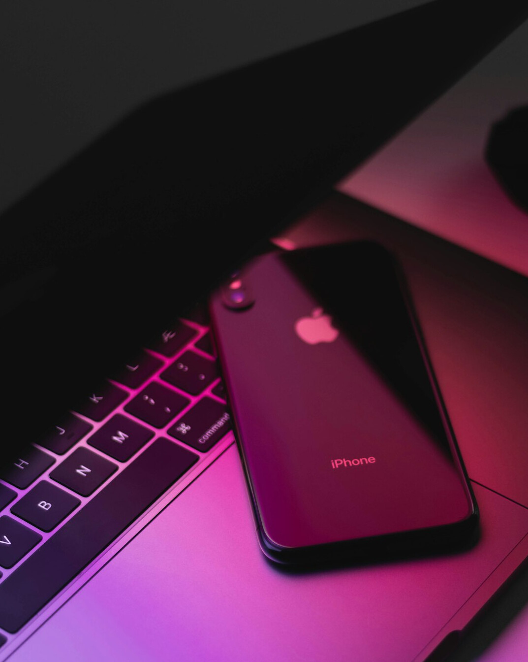Laptop with code next to a phone and notes